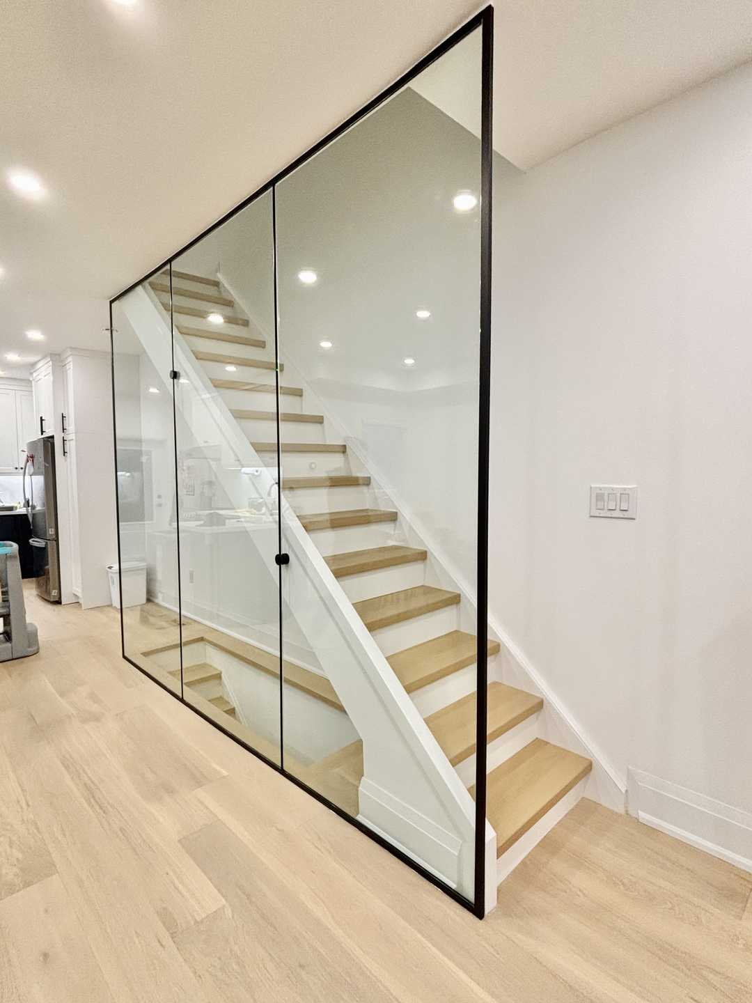 Medium-tone wood coloured hardwood flooring with glass partitions